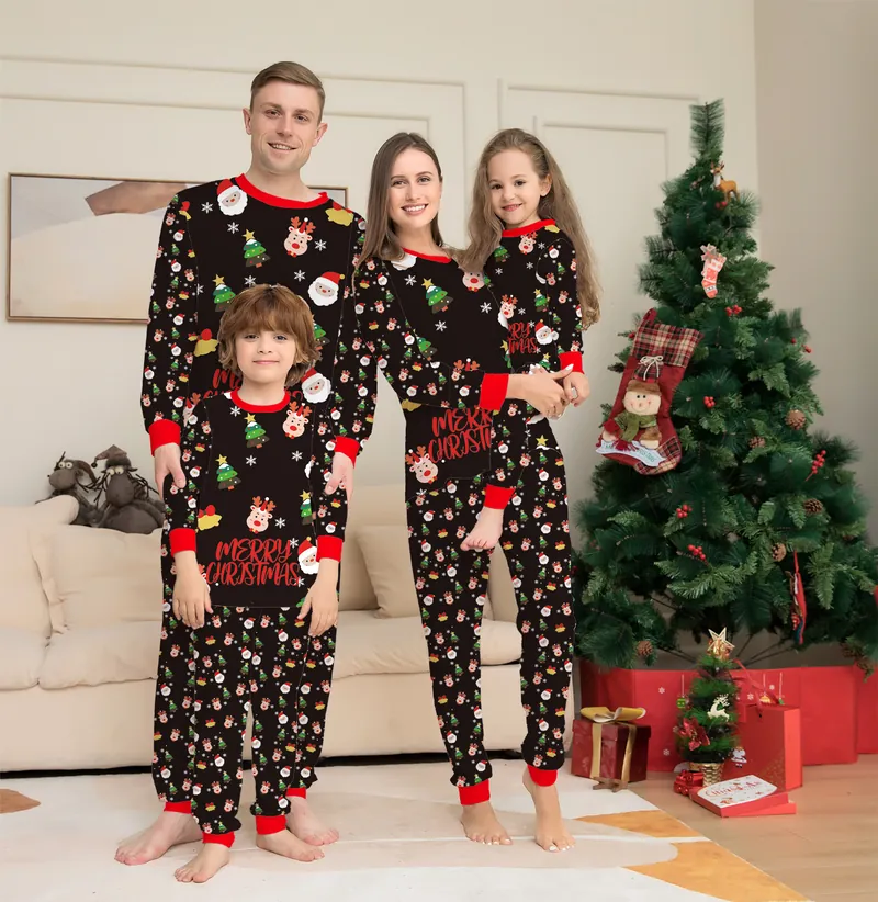 Famille de quatre en pyjamas de Noël assortis devant un sapin